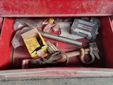 a red tool box with tools in it on the sidewalk