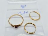 three gold rings with garnetts on them sitting on top of a piece of paper