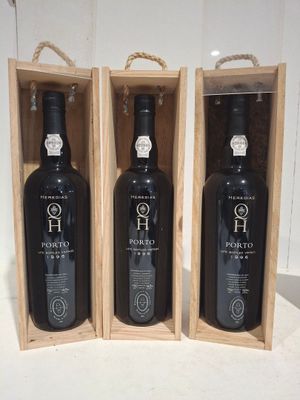 trois bouteilles de vin dans un coffret en bois sur une table