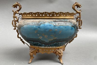 un vase bleu et or posé sur un socle, sur une surface grise
