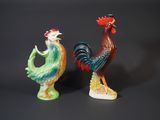 two figurines of roosters standing next to each other