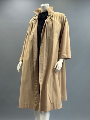 an image of a mannequin wearing a tan coat and black shirt