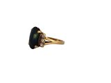 a gold ring with a black stone and two white diamonds
