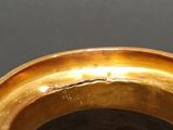 an image of a close up of a gold ring on a table