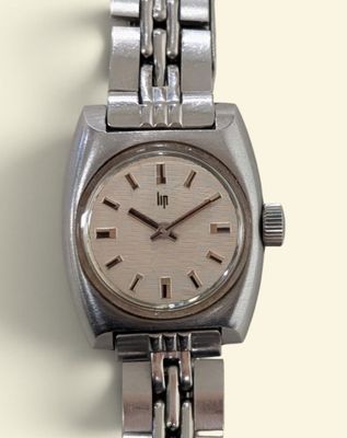 a watch that is sitting on a silver bracelet