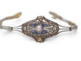 un gros plan sur un bracelet manchette orné d'un diamant et d'une perle