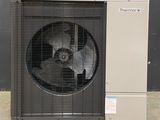 an air conditioner sitting on the floor in front of a gray wall