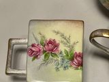 a small box with flowers painted on it next to a pair of scissors