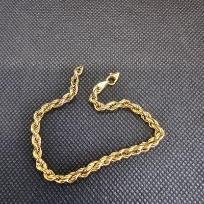 un bracelet à chaîne en or avec un fermoir sur fond noir