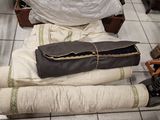 a pile of pillows sitting on the floor next to a suitcase