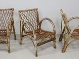 trois chaises en osier placées les unes à côté des autres sur un sol carrelé