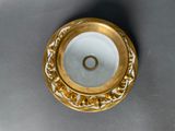 a gold plate with a ring in it on a table