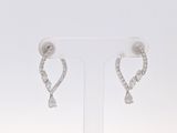 une paire de boucles d'oreilles en diamant posée sur un présentoir, sur fond blanc