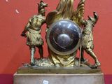 une statue représentant un homme tenant un globe terrestre posé sur une table