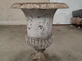 a white vase that is sitting on a cement stand