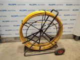 a yellow hose sitting on a cart in front of a wall