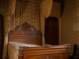 un lit à baldaquin dans une chambre avec du parquet