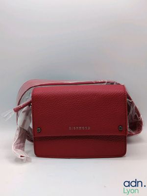 un sac à main rouge auquel est attaché un sac en plastique transparent