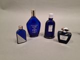 three bottles of perfume sitting on a white surface next to each other