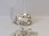 a glass filled with coins sitting on a table