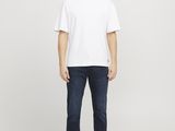 a man in a white t - shirt and jeans stands in front of a white background