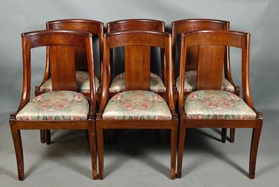 quatre chaises dotées de coussins rembourrés à motifs floraux sont posées sur une surface grise