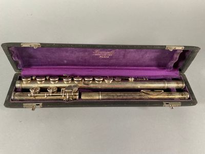 a flute in a case with a purple cloth inside