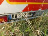 a red and yellow bus that is parked in the grass