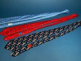 three ties are lined up in a row on a blue surface