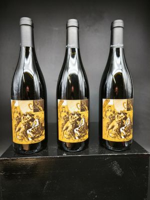 trois bouteilles de vin posées sur un bloc de bois