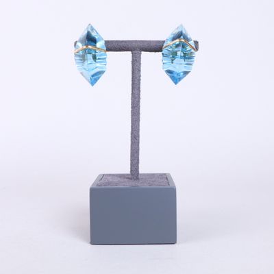 un gros plan sur une paire de boucles d'oreilles bleues posées sur un présentoir