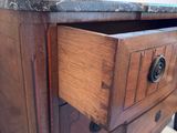 a wooden dresser with a marble top and drawers