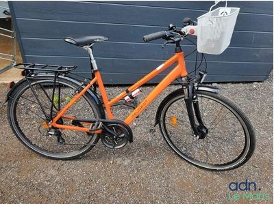 un vélo orange garé devant un garage bleu