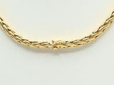 a close up of a gold necklace on a mannequin mannequin