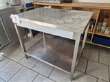 a stainless steel table in the middle of a kitchen