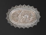 une assiette en argent ornée d'un dragon sur fond noir