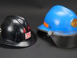 two hard hats sitting next to each other on a black background