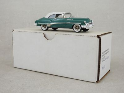 une petite voiture verte posée sur une boîte