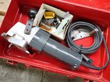 une boîte rouge contenant des outils, posée sur le sol