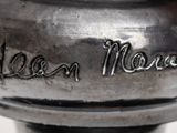 a close up of a silver vase with writing on it
