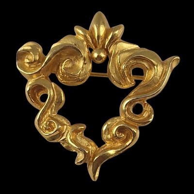 an image of a gold broochle with a heart shaped design