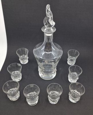 an image of a glass decanter and six shot glasses on a table