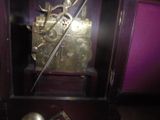 une horloge posée dans un coffret contenant une épée