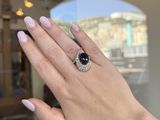 the woman is wearing a ring that has a black stone on it