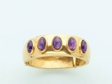 a close up of a gold ring with purple stones on it