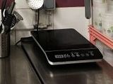 une plaque de cuisson noire posée sur un plan de travail dans une cuisine