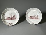 deux assiettes avec des oiseaux peints dessus, posées sur une table