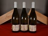 three bottles of wine sitting on a red cloth next to a wooden box