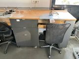 a desk with two chairs and a computer on it