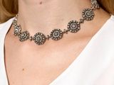 the woman is wearing a white shirt and a silver necklace